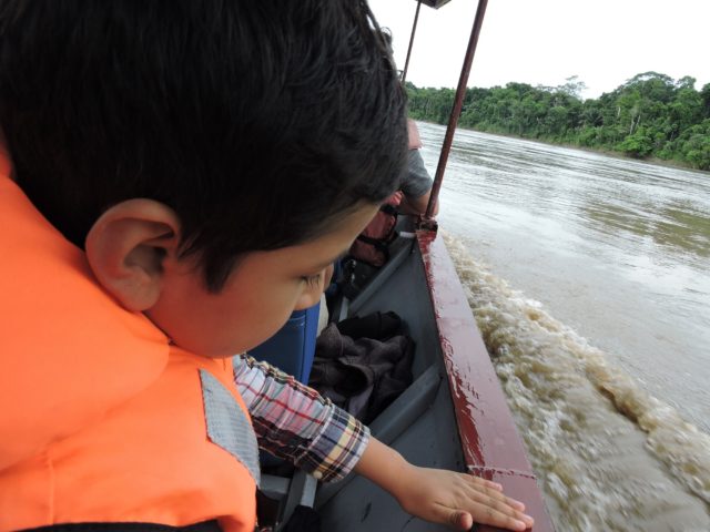 Things to do in Manu National Park with kids - 7 years old children traveling by river boat on the manu river